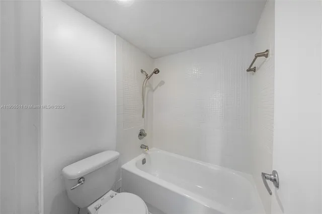 a bathroom with a toilet and a bath tub