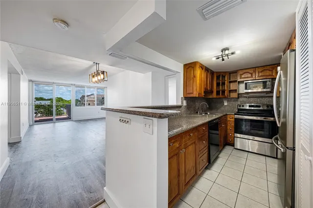 a kitchen with stainless steel appliances granite countertop a refrigerator and a stove top oven