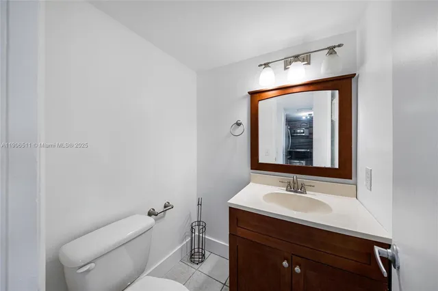 a bathroom with a sink vanity mirror and toilet
