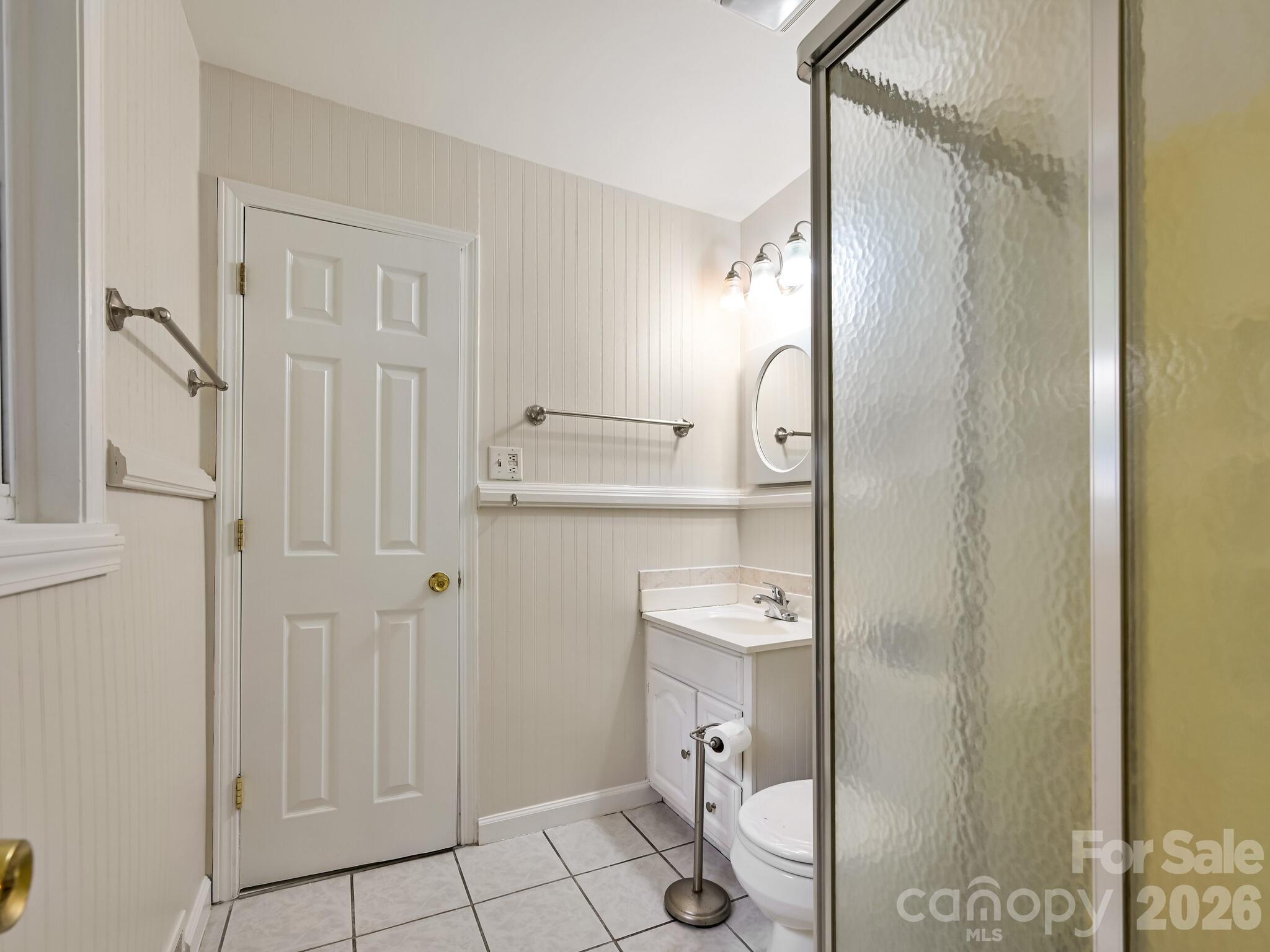651 Case Cove Road Candler, NC 28715 - Photo 12 of 45 a bathroom with a granite countertop shower a toilet and a sink