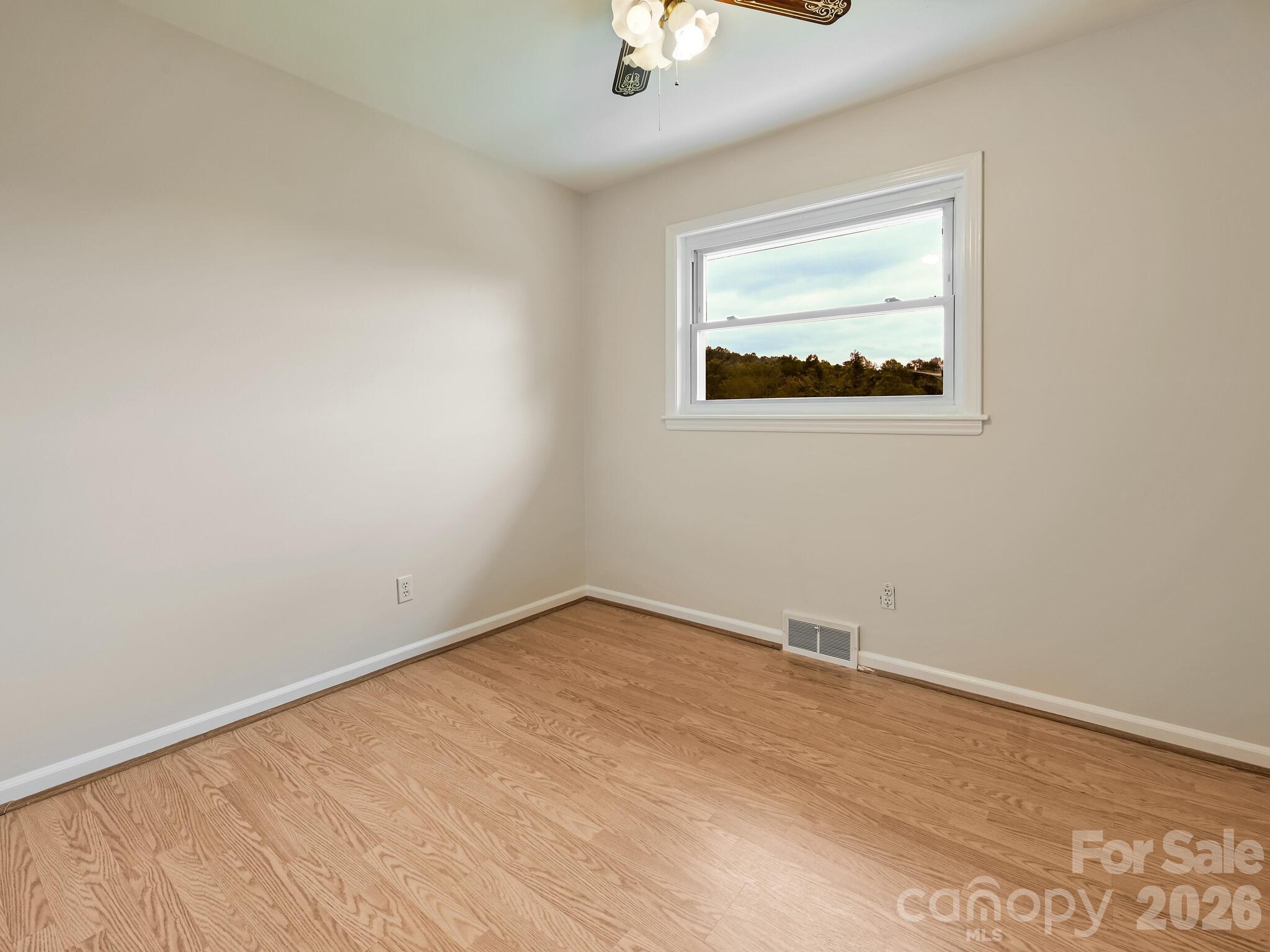 651 Case Cove Road Candler, NC 28715 - Photo 13 of 45 an empty room with wooden floor and windows
