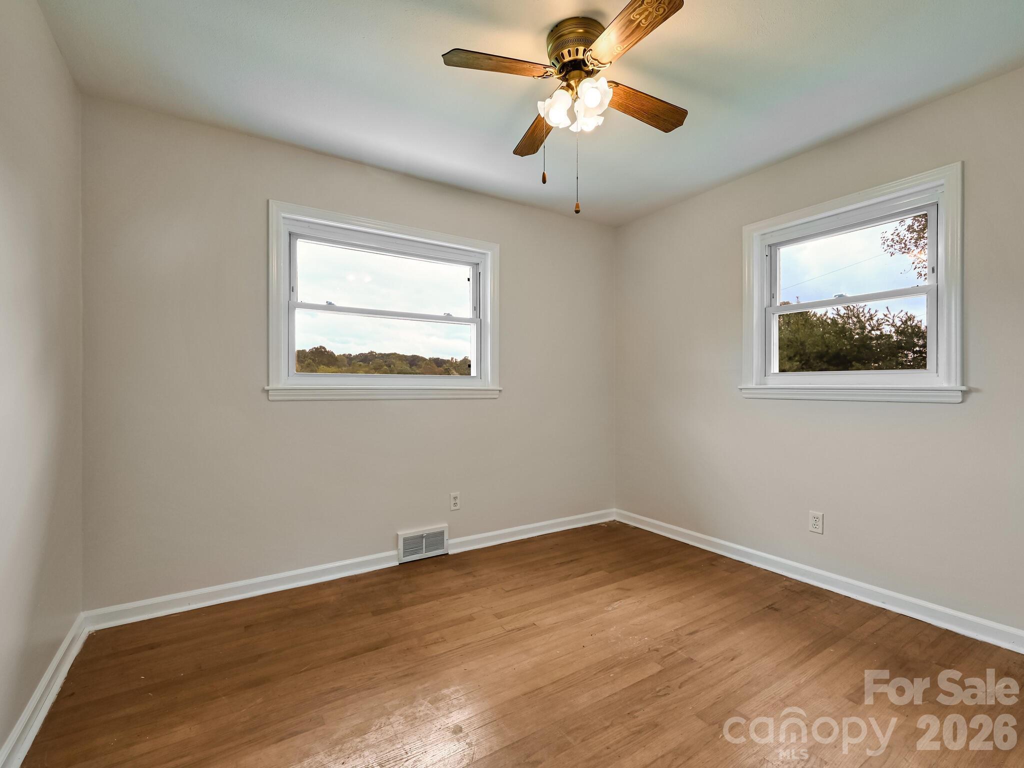 651 Case Cove Road Candler, NC 28715 - Photo 14 of 45 a view of a big room with wooden floor and windows
