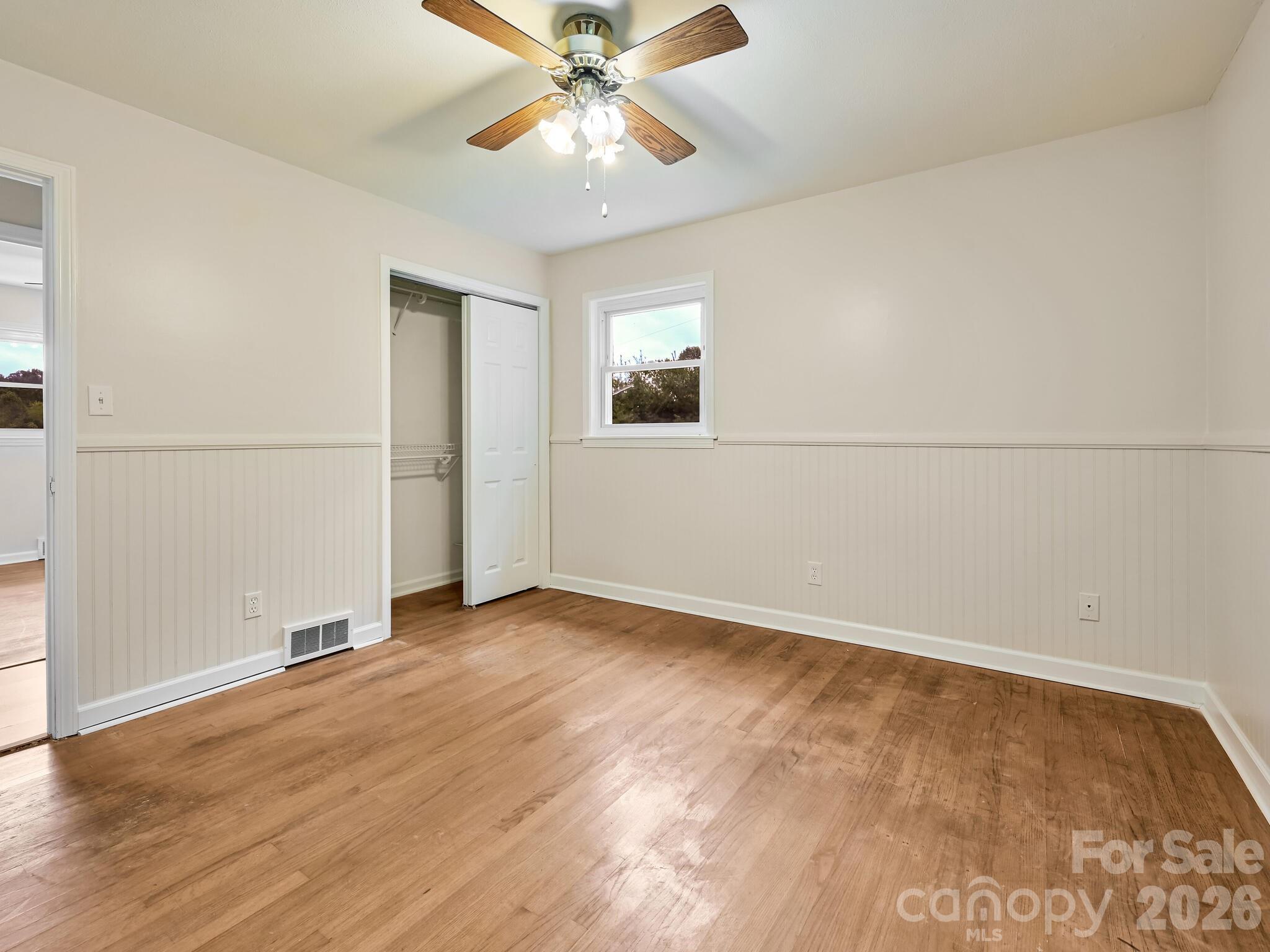651 Case Cove Road Candler, NC 28715 - Photo 10 of 45 an empty room with wooden floor closet and windows