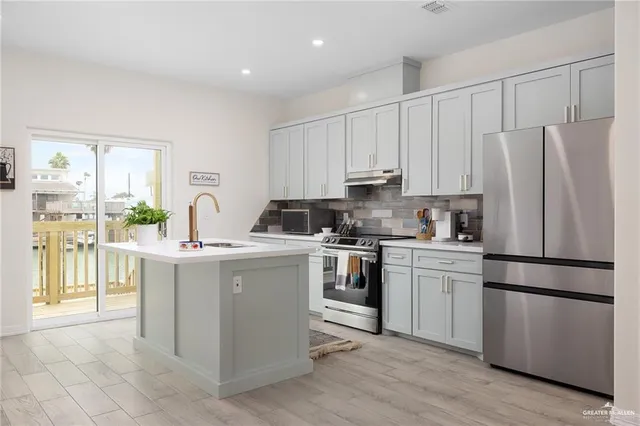 a kitchen with a refrigerator stove and white cabinets