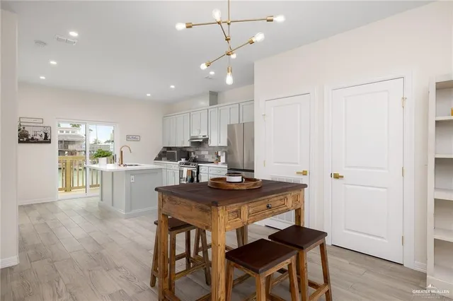 a kitchen with kitchen island a stove a table and chairs in it