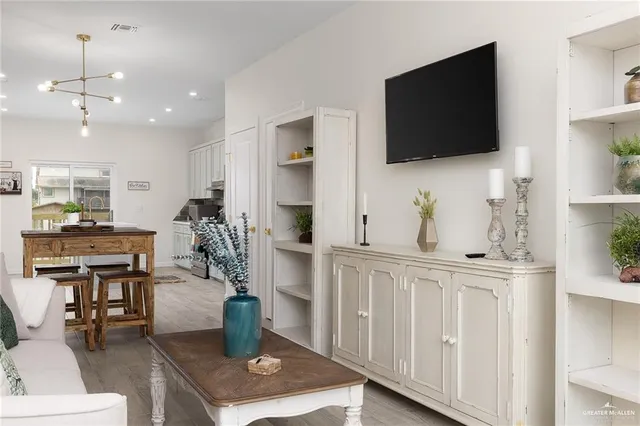 a living room with furniture a flat screen tv and kitchen view