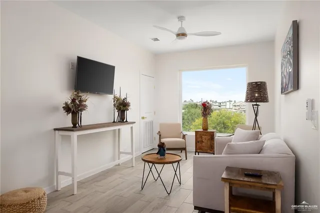 a living room with furniture a chandelier and a flat screen tv
