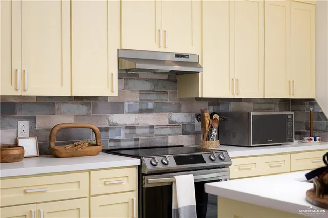 a kitchen with stainless steel appliances granite countertop a stove and a white cabinets