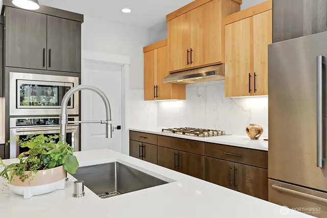 a kitchen with stainless steel appliances granite countertop a sink stove and refrigerator