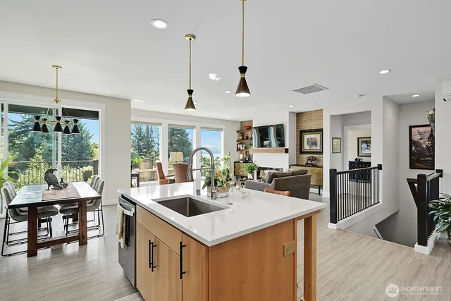 a kitchen with stainless steel appliances granite countertop a sink a stove and a wooden floor