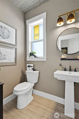 a bathroom with a toilet a sink and mirror