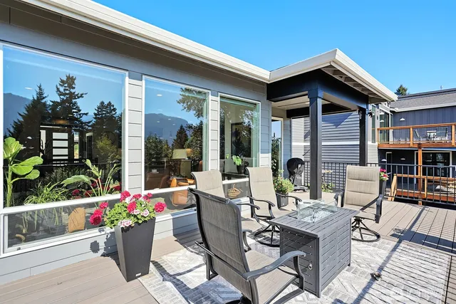 a view of a patio with table and chairs potted plants and floor to ceiling window