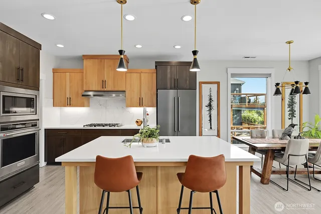 a kitchen with stainless steel appliances kitchen island granite countertop a kitchen island a table and chairs in it