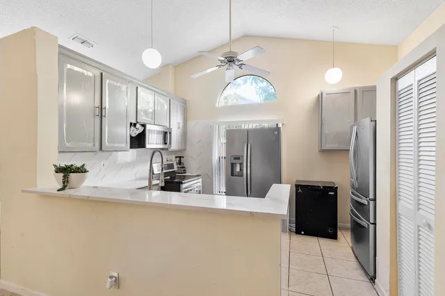 a kitchen with stainless steel appliances a refrigerator and microwave