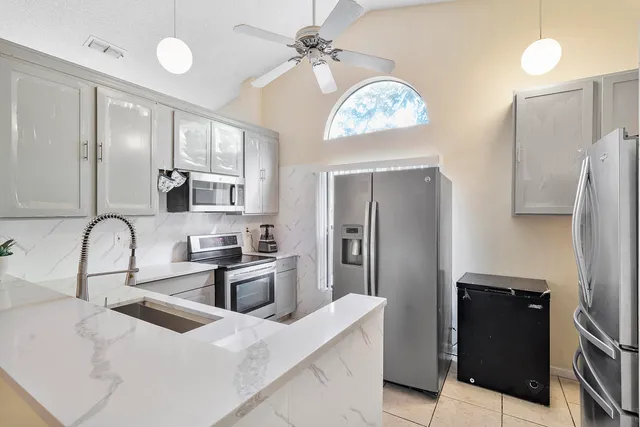 a kitchen with stainless steel appliances granite countertop a refrigerator a stove a sink and a refrigerator