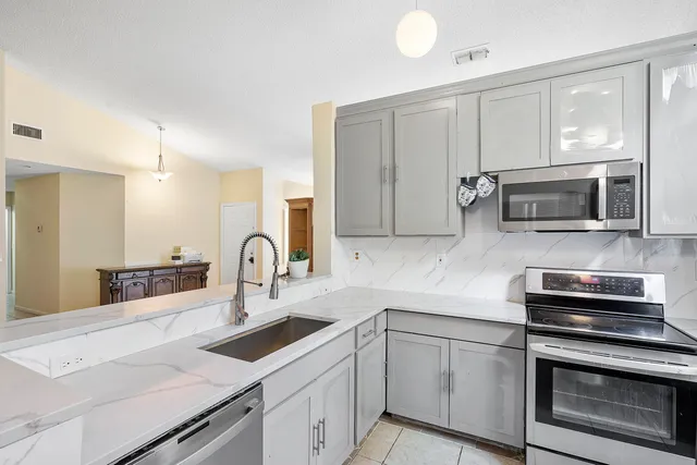 a kitchen with appliances a sink cabinets and a counter top space