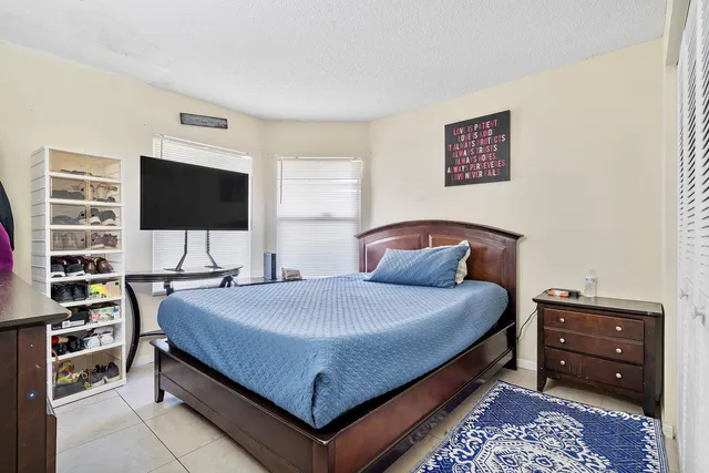 a bedroom with bed and a flat screen tv