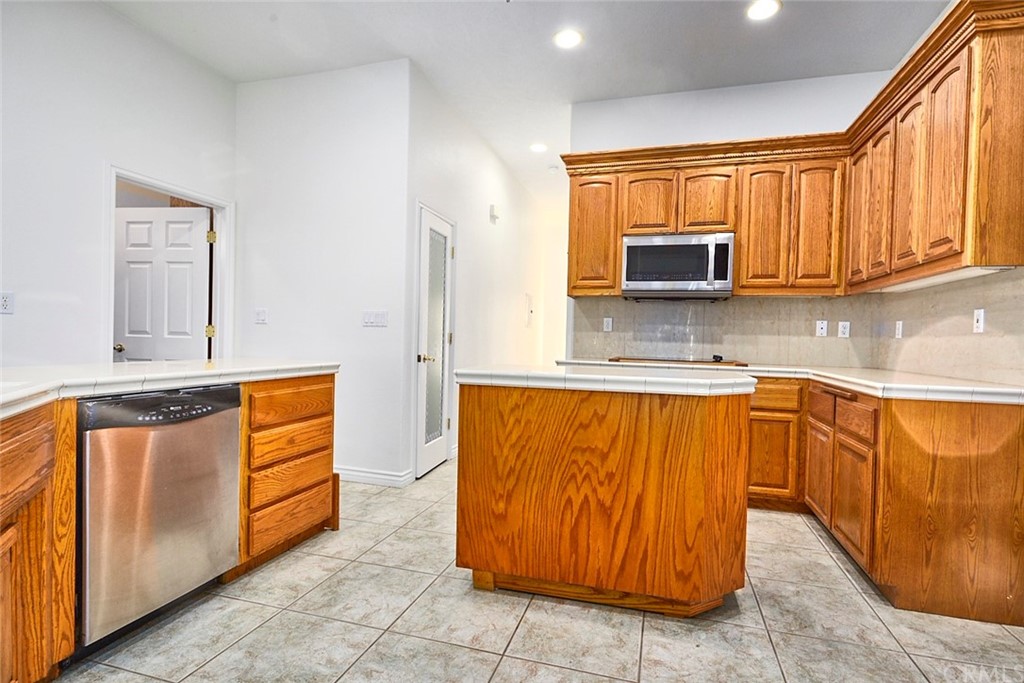 8250 Cataba Road Oak Hills, CA 92344 - Photo 15 of 53 a kitchen with stainless steel appliances granite countertop a stove a sink and a microwave