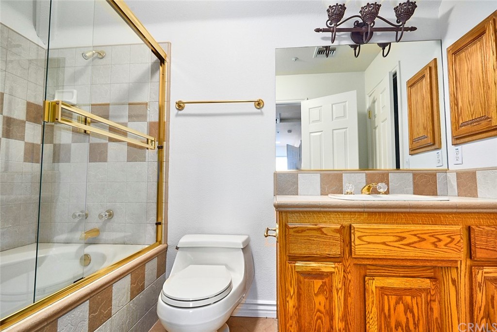 8250 Cataba Road Oak Hills, CA 92344 - Photo 35 of 53 a bathroom with a granite countertop sink a toilet and shower