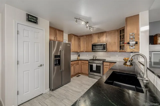 a kitchen with stainless steel appliances granite countertop a refrigerator stove and sink