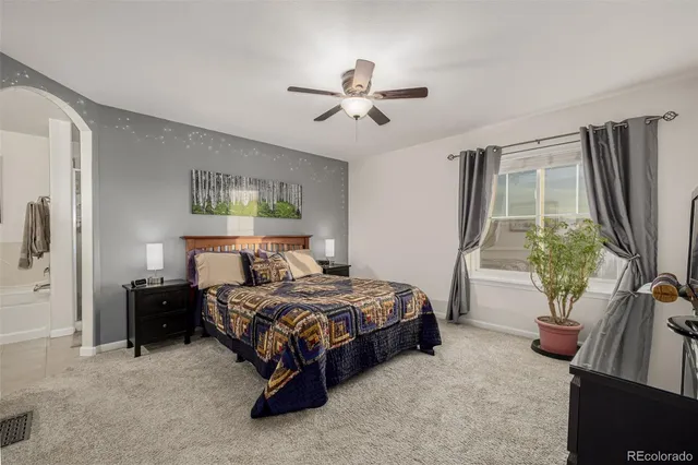 a bedroom with a bed couch and a window