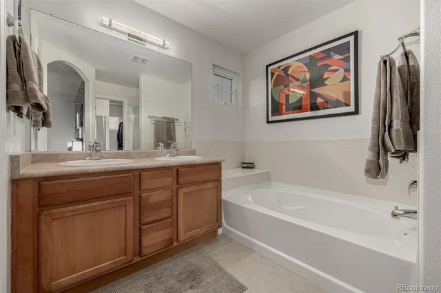 a bathroom with a tub sink and mirror