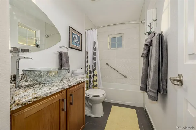 a bathroom with a granite countertop sink toilet and shower