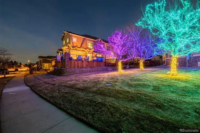 a view of a yard with plants and a barbeque