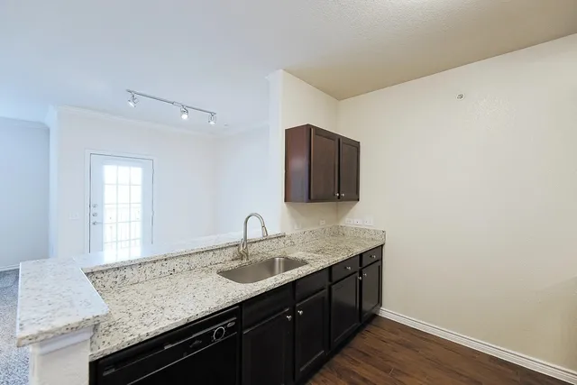 a bathroom with a granite countertop sink a mirror and wooden cabinets