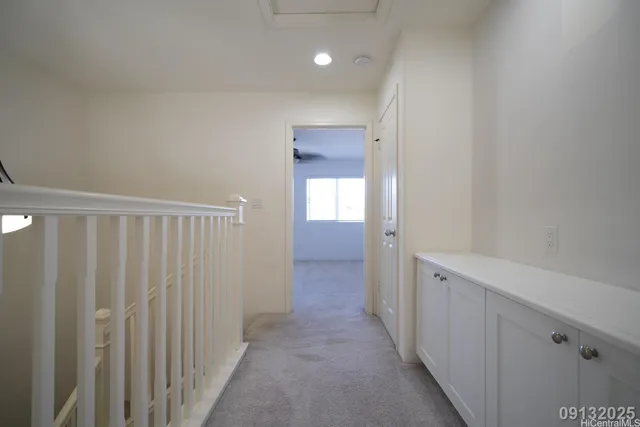 a view of a hallway with wooden cabinets and stairs