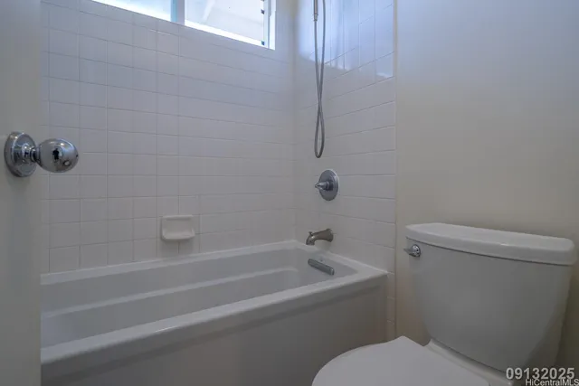 a white toilet sitting next to a bath tub