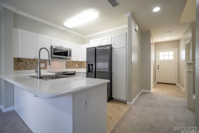 a kitchen with kitchen island a sink stove and refrigerator