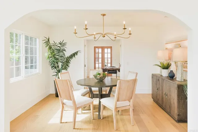 a kitchen with a stove a sink a dining table and chairs
