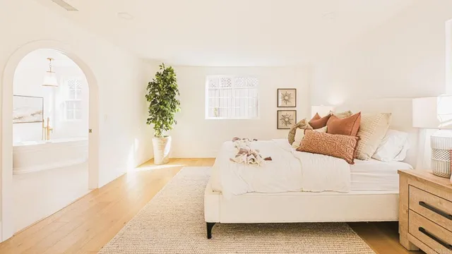 a living room with couches and kitchen view with wooden floor