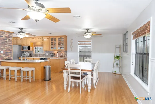 a dining room with furniture a chandelier and wooden floor