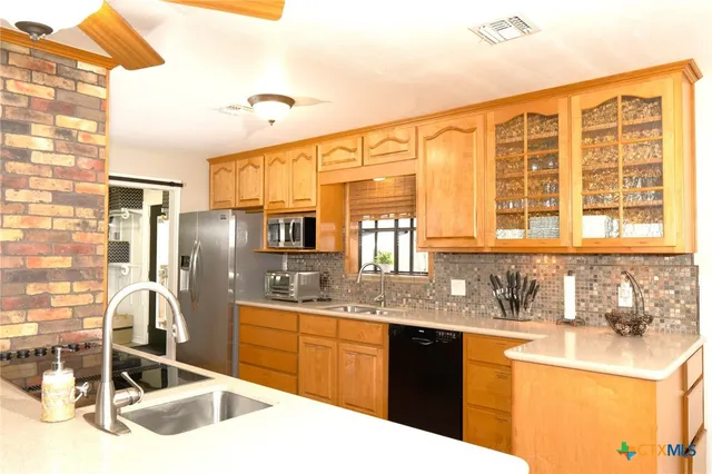 a kitchen with granite countertop a sink and a refrigerator