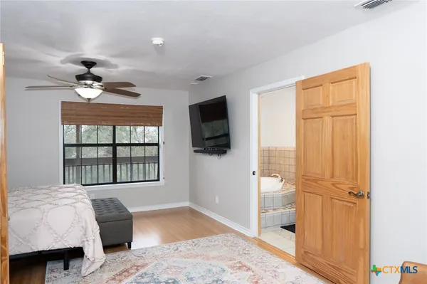a living room with a bed furniture and a flat tv screen