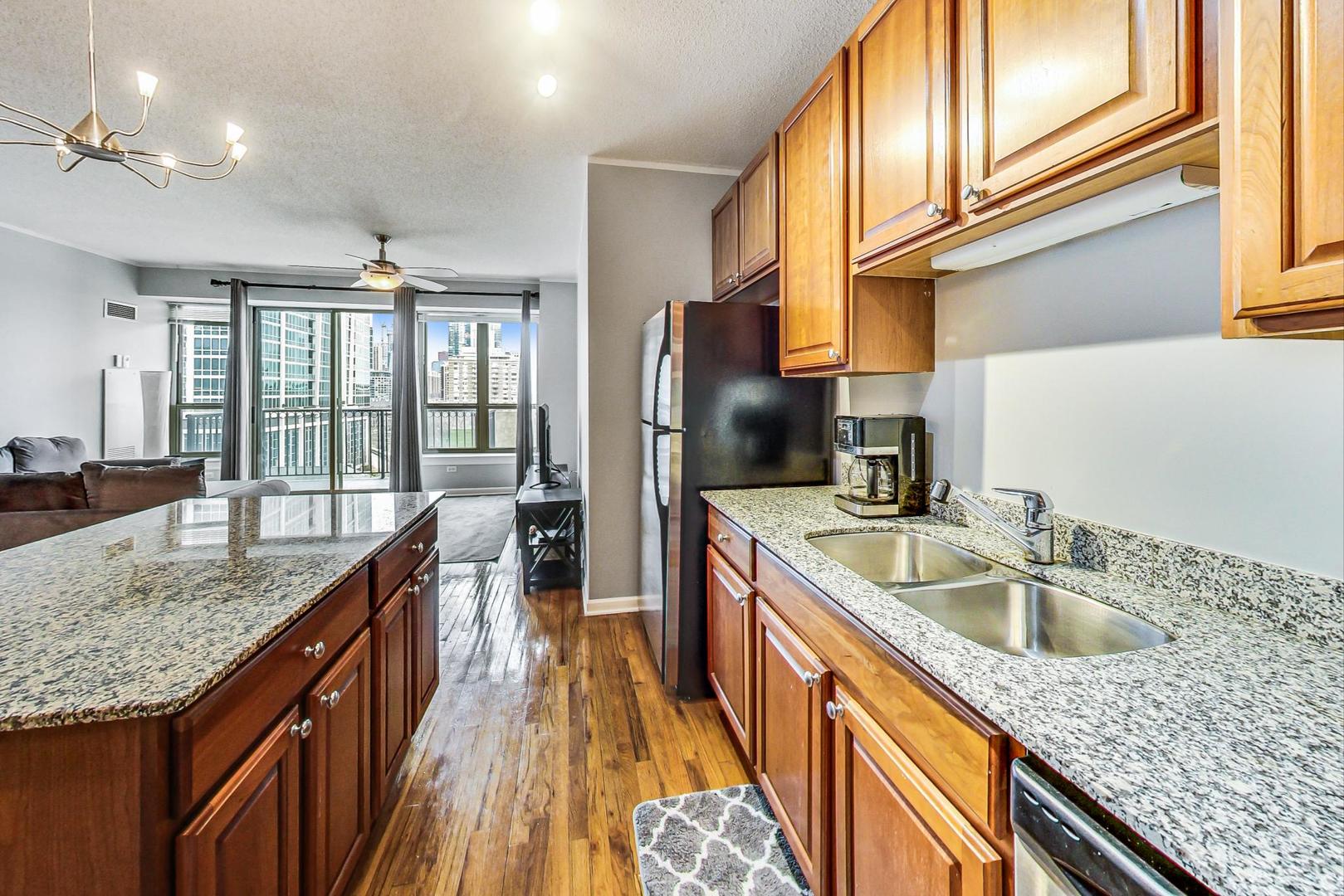 1717 South Prairie Avenue, Unit 802 Chicago, IL 60616 - Photo 8 of 33 a kitchen with stainless steel appliances granite countertop a sink a stove and a wooden cabinets
