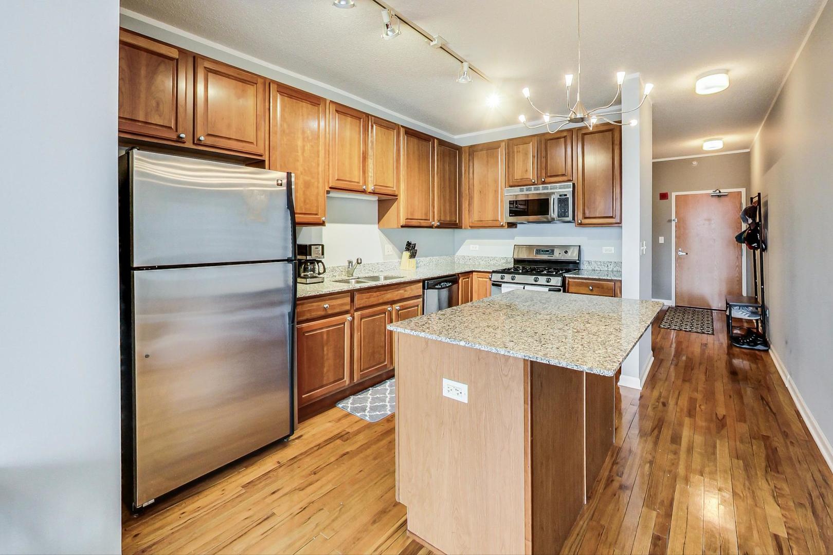 1717 South Prairie Avenue, Unit 802 Chicago, IL 60616 - Photo 9 of 33 a kitchen with kitchen island a counter top space a sink a refrigerator and a stove top oven