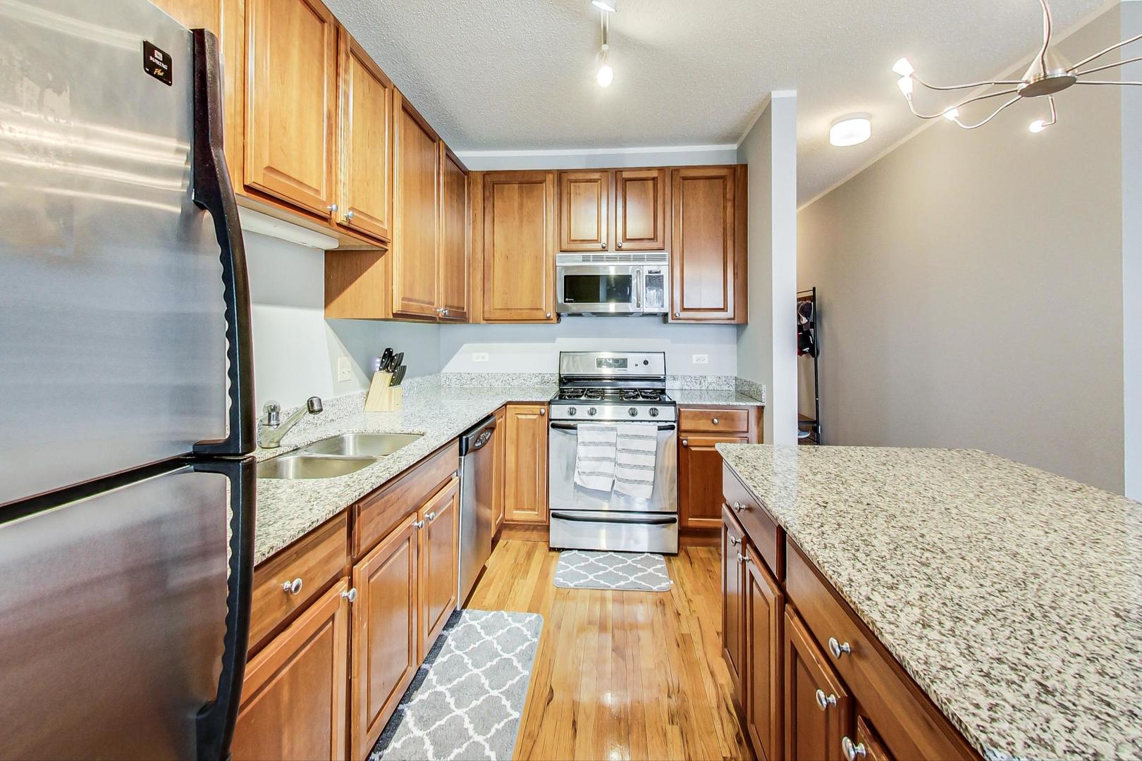 1717 South Prairie Avenue, Unit 802 Chicago, IL 60616 - Photo 10 of 33 a kitchen with kitchen island granite countertop a sink a counter top space appliances and cabinets