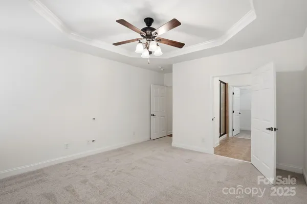 an empty room with ceiling fan and window