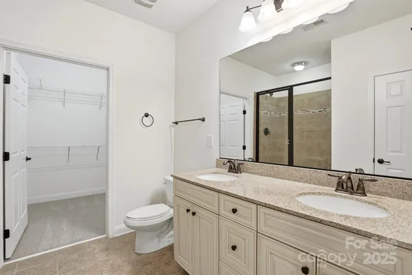 a bathroom with a granite countertop sink toilet a large mirror