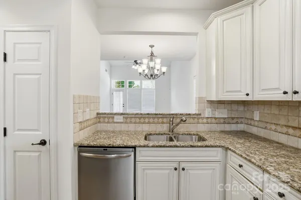 a kitchen with stainless steel appliances granite countertop a sink and a white cabinets