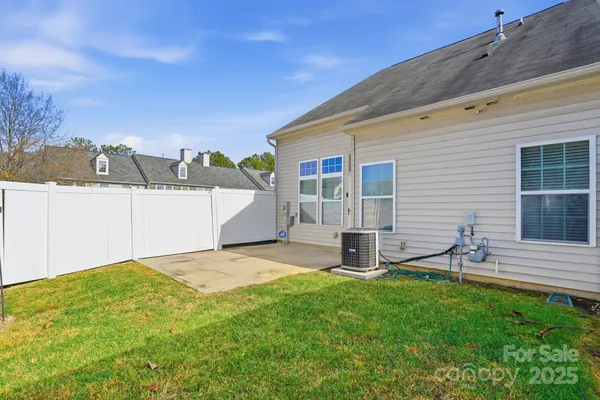 a view of a backyard with table and chairs and wooden fence