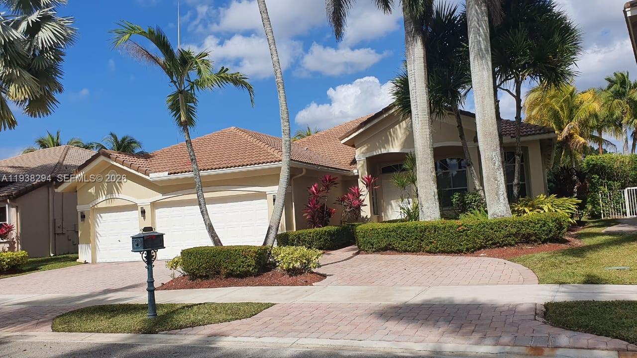 a front view of a house with a yard and potted plants