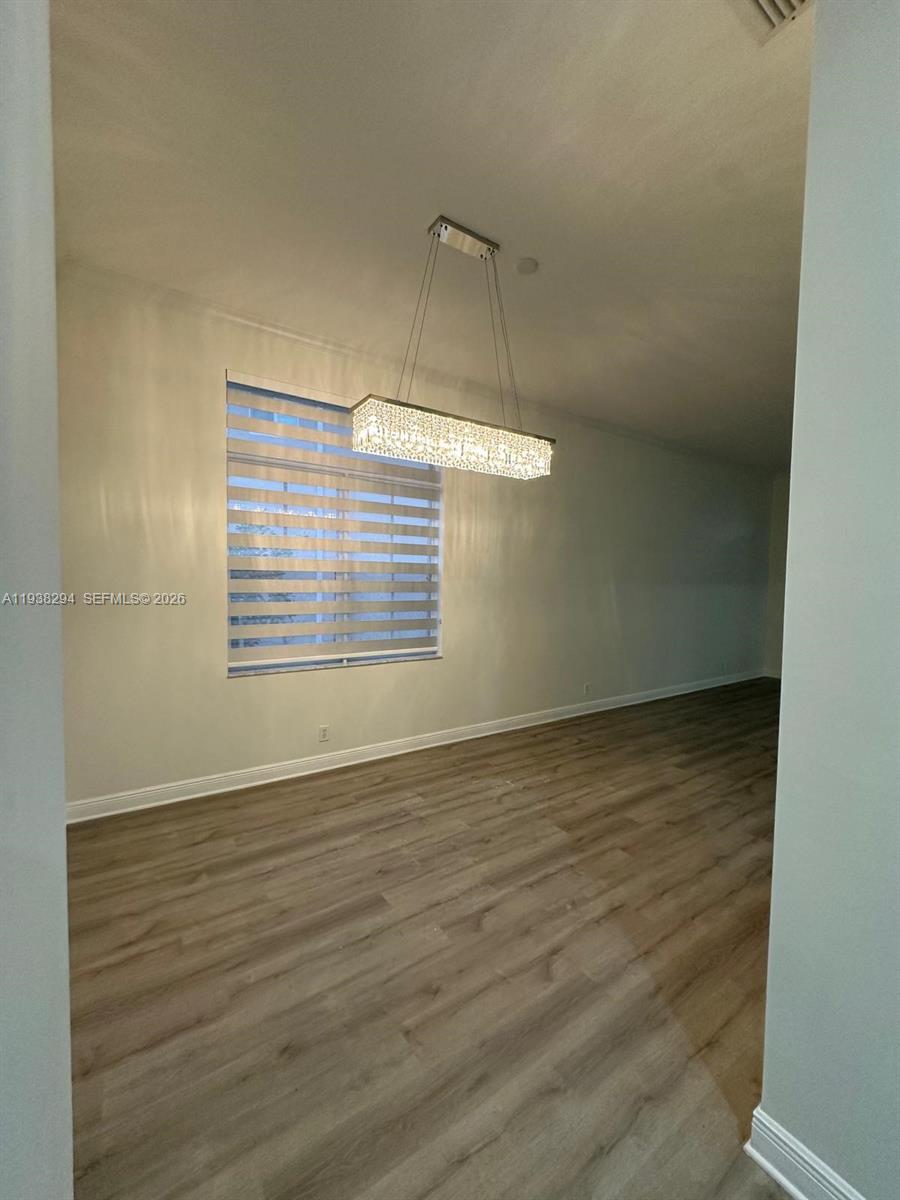 2408 Deer Creek Road Weston, FL 33327 - Photo 11 of 30 a view of an empty room with wooden floor and a window