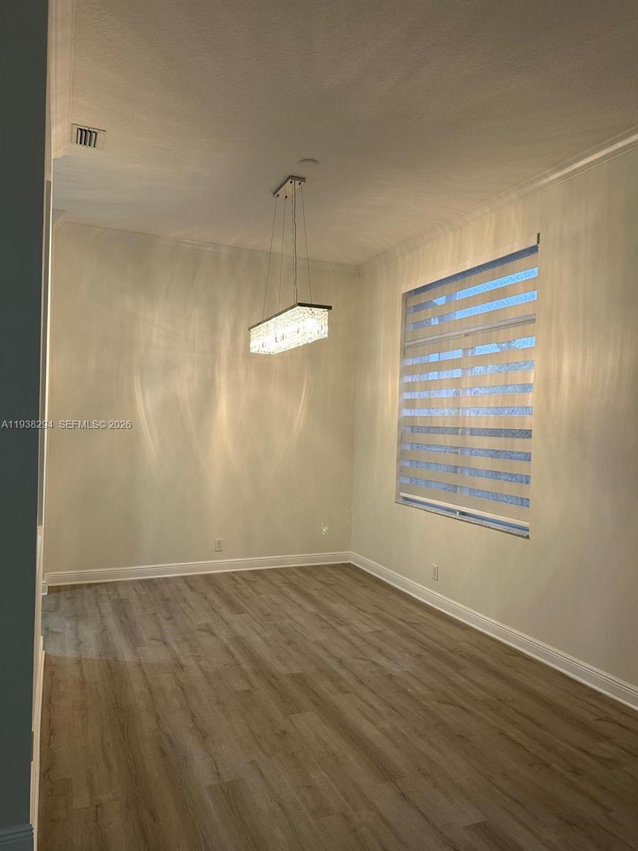 2408 Deer Creek Road Weston, FL 33327 - Photo 12 of 30 a view of an empty room with wooden floor and a window