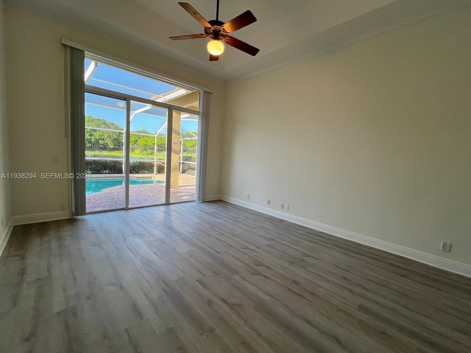 2408 Deer Creek Road Weston, FL 33327 - Photo 14 of 30 an empty room with wooden floor fan and windows