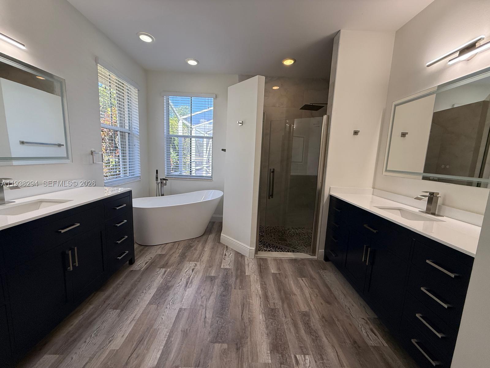 2408 Deer Creek Road Weston, FL 33327 - Photo 16 of 30 a spacious bathroom with a double vanity sink a mirror and a bathtub