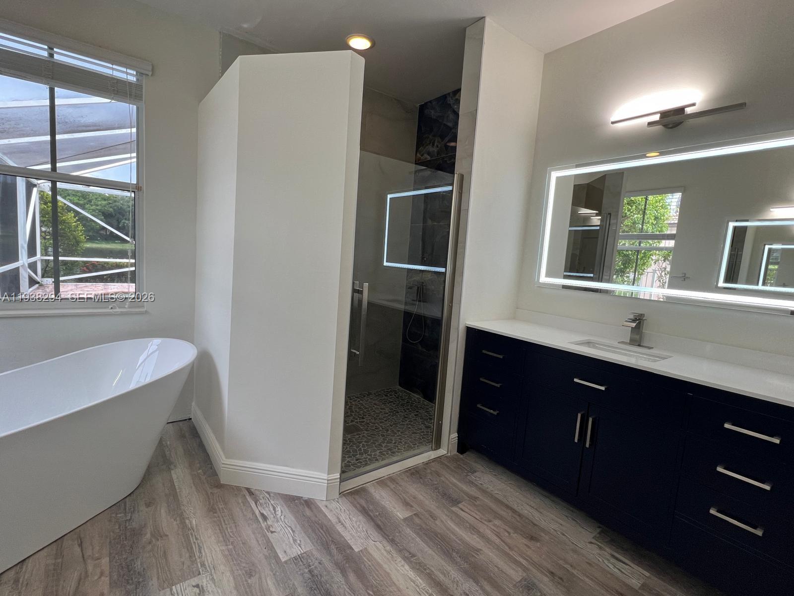 2408 Deer Creek Road Weston, FL 33327 - Photo 17 of 30 a spacious bathroom with a double vanity sink a large mirror and a bathtub